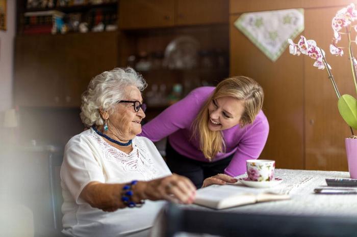 A carer smiling at an elderly patient